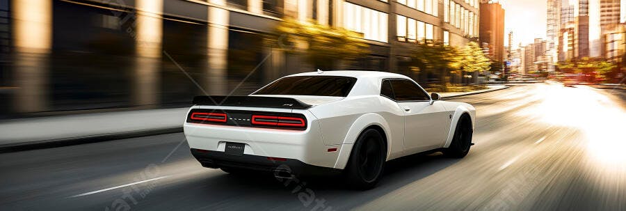 Carro esportivo branco Dodge Challenger dirigindo rápido na cidade ao pôr do sol