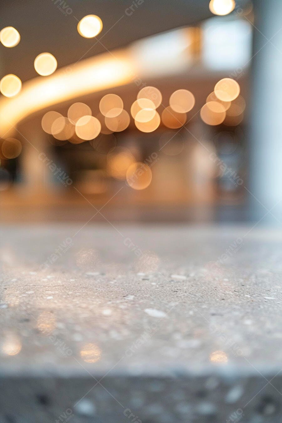 Bancada de pedra cinza com luzes bokeh douradas desfocadas ao fundo