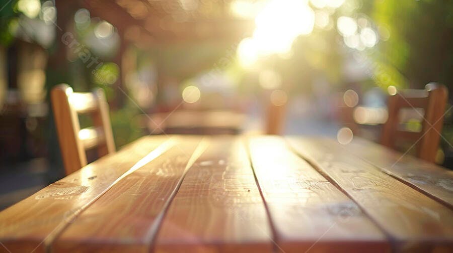 Mesa de madeira em terraço ao ar livre com sol brilhante e cadeiras desfocadas