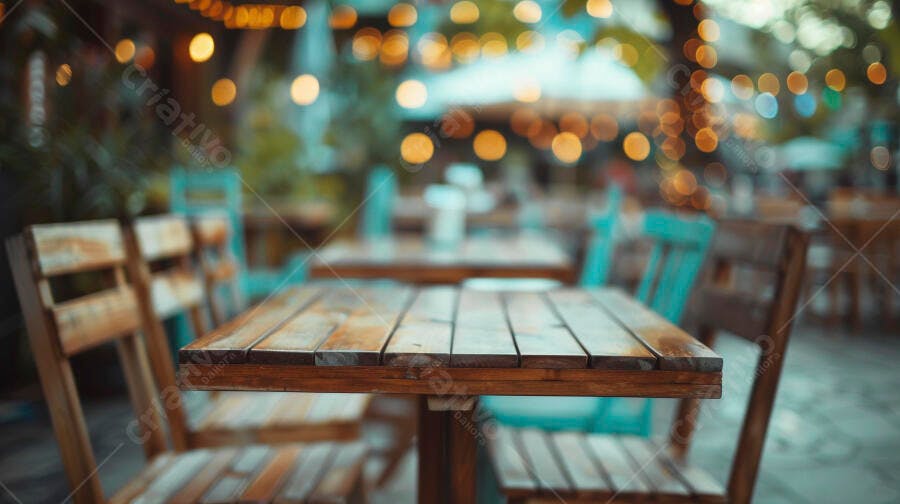 Mesa de madeira rústica em restaurante ao ar livre com luzes bokeh