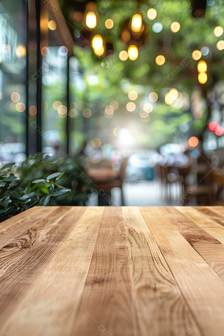Mesa de madeira clara em café urbano com luzes bokeh e plantas verdes