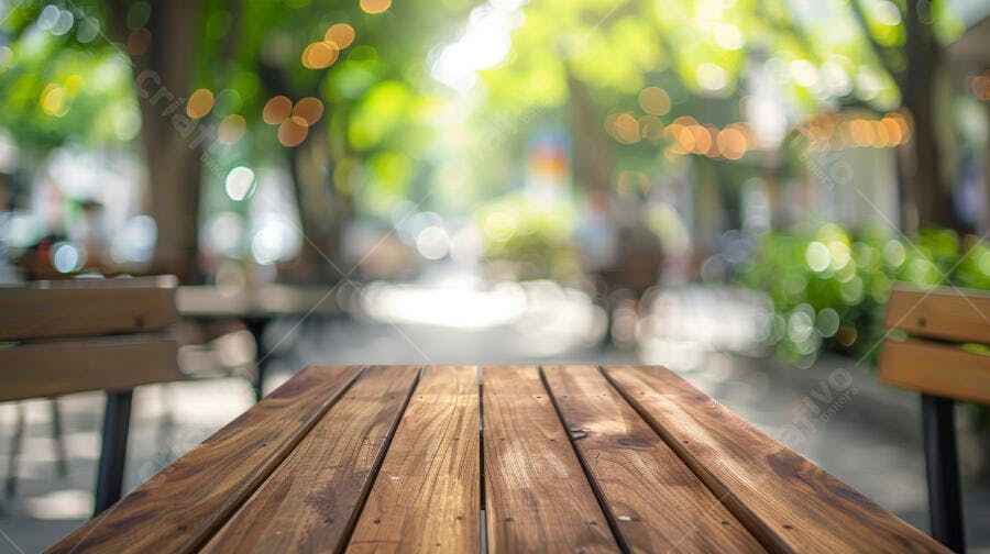 Mesa de madeira rústica em café ao ar livre com fundo bokeh verde e luzes