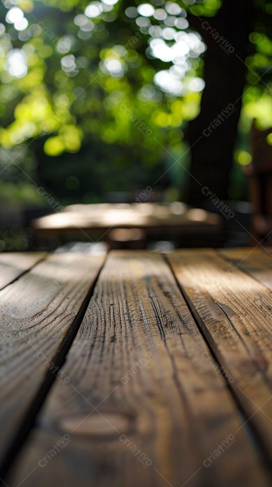 Mesa de madeira rústica com luz solar e folhas verdes desfocadas ao ar livre