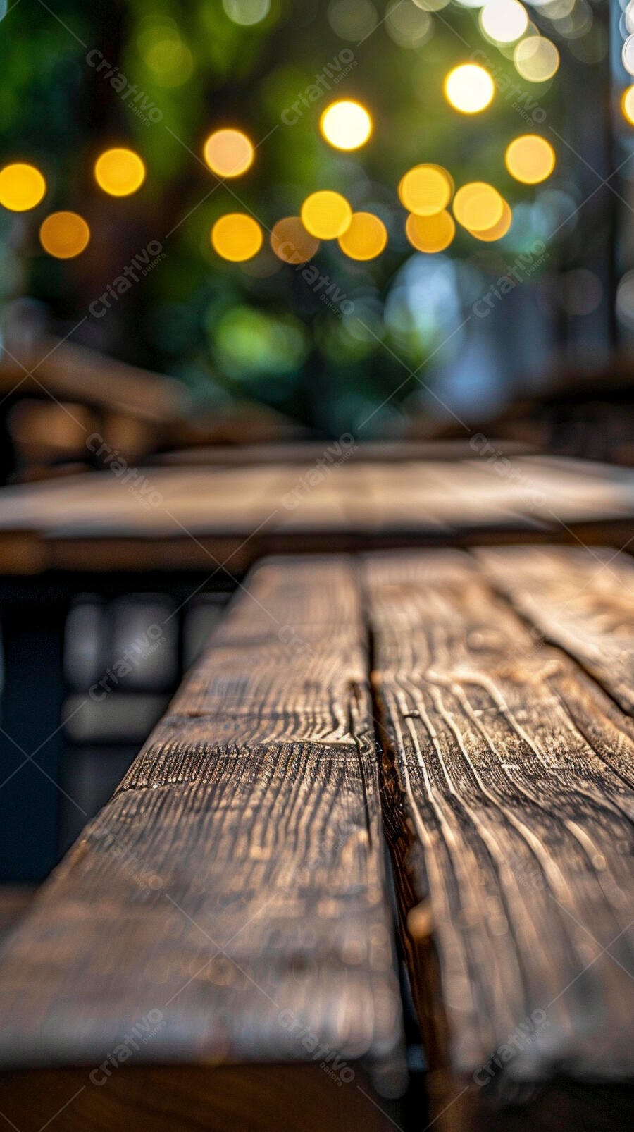 Mesa de madeira rústica com luzes bokeh e folhagem verde ao ar livre à noite