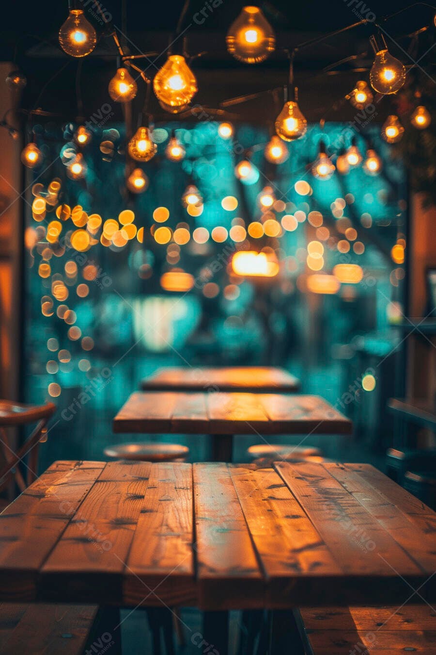 Mesas de madeira e luzes de corda em café aconchegante à noite