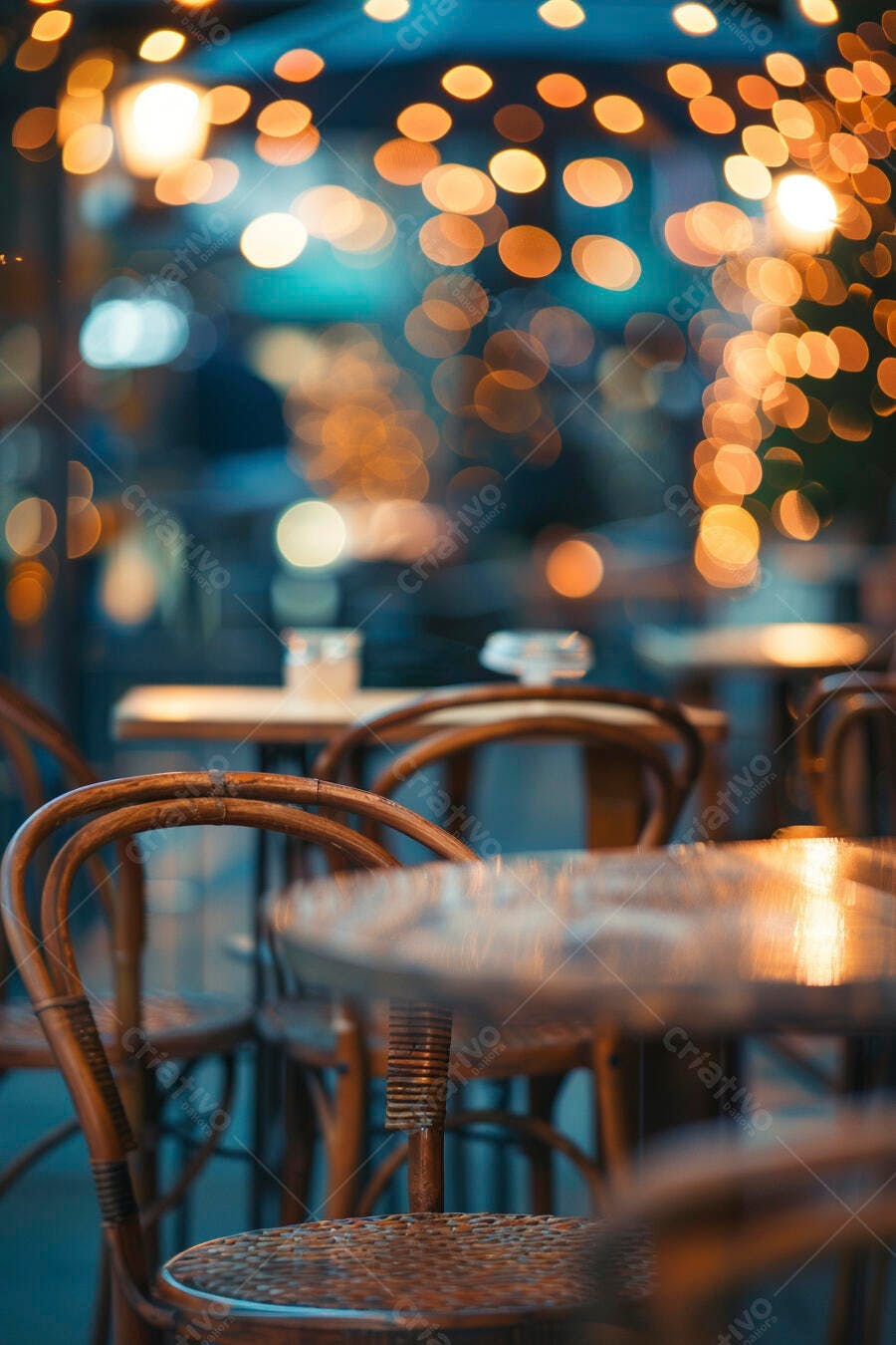 Mesas e cadeiras de madeira em café noturno com luzes bokeh quentes