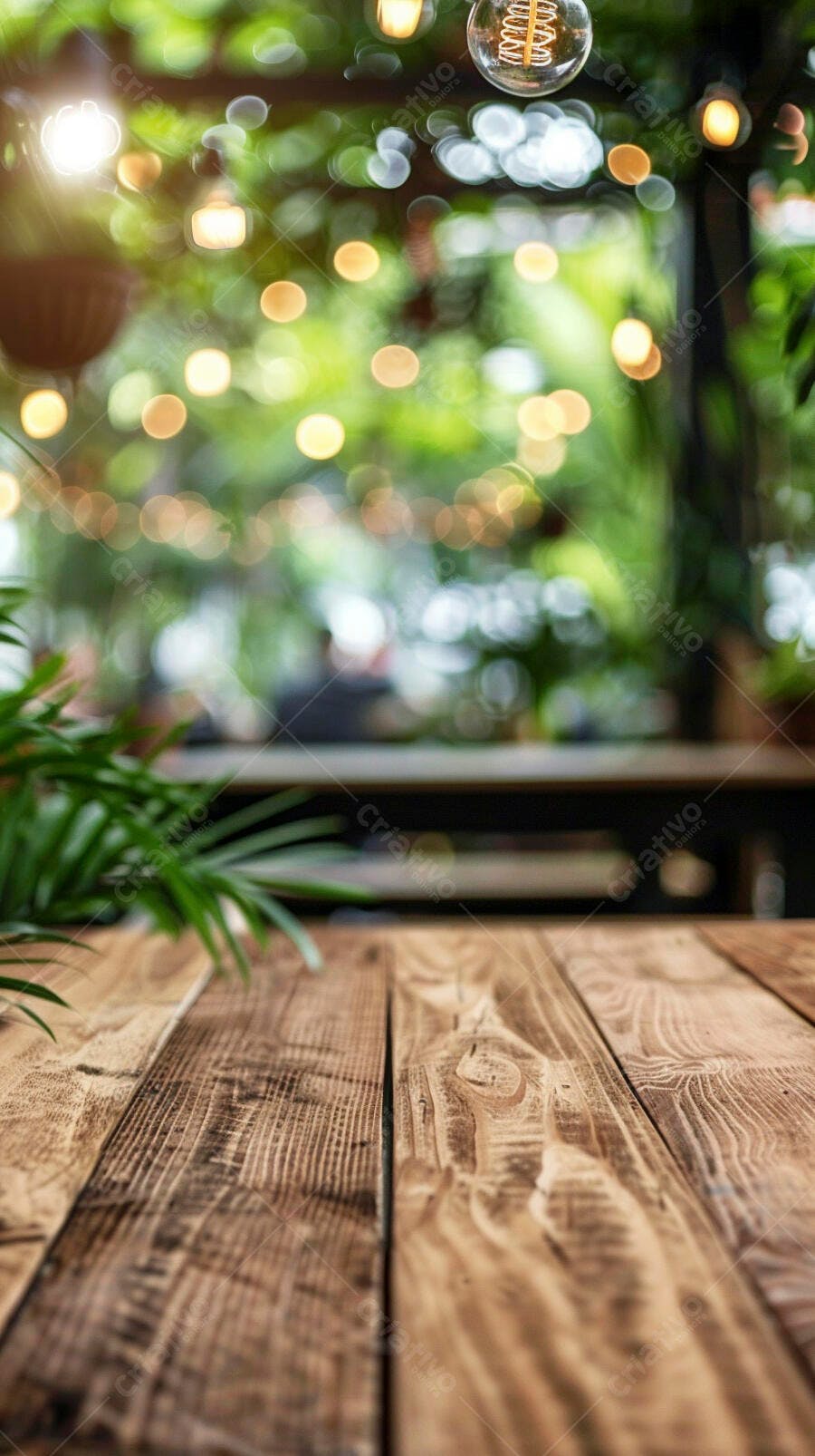 Mesa de madeira vazia em café com luzes bokeh e folhagem verde