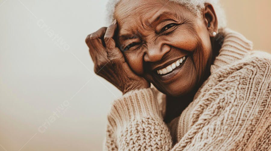 Mulher idosa negra rindo alegremente em suéter de tricô bege