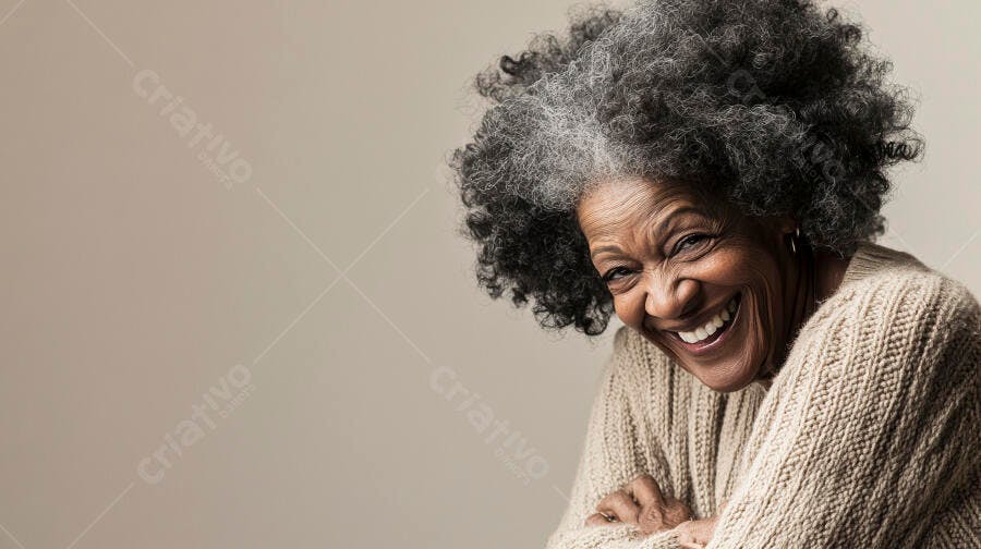 Mulher negra idosa com cabelo grisalho suéter bege sorrindo genuinamente