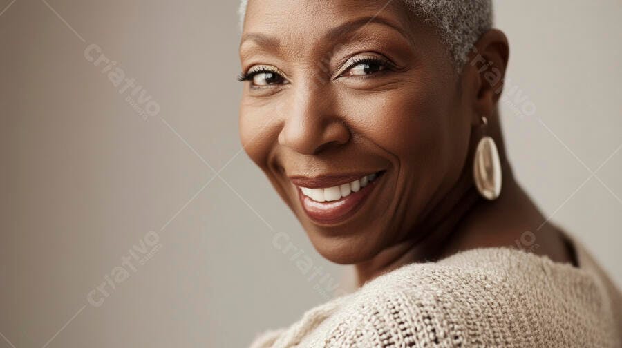 Mulher negra idosa com cabelos grisalhos sorrindo feliz em suéter bege