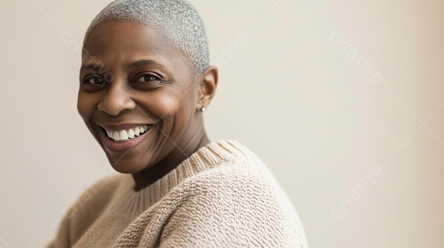 Mulher negra madura sorrindo com cabelo grisalho curto e blusa bege