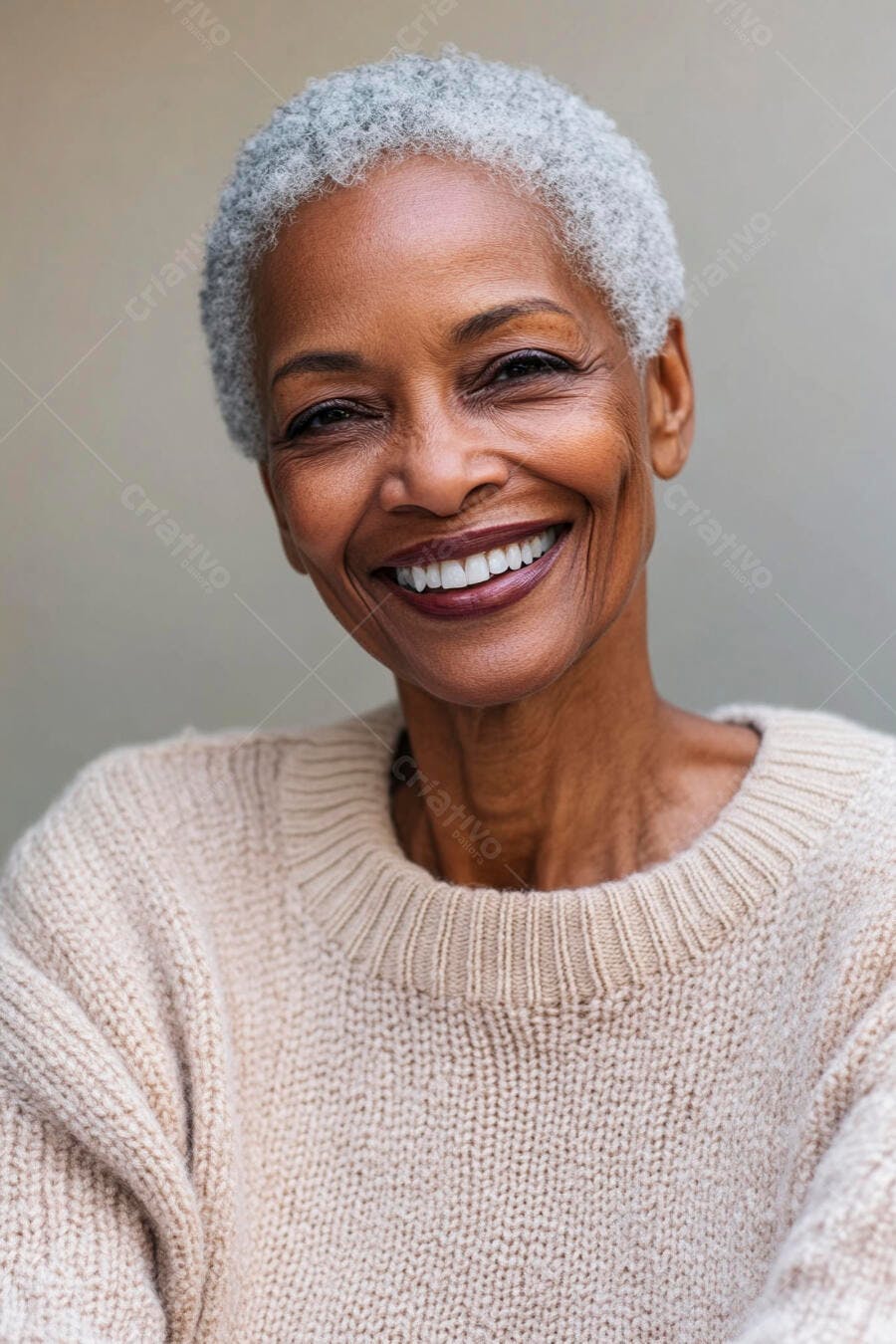 Mulher negra idosa sorrindo com cabelo grisalho e suéter bege em retrato feliz