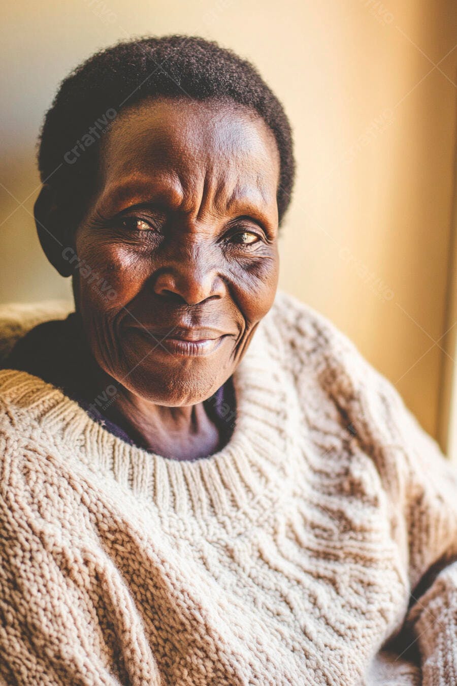 Mulher negra idosa sorrindo com suéter de tricô bege em ambiente acolhedor