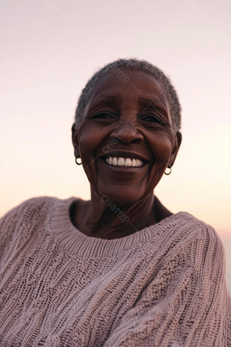 Mulher negra idosa sorrindo feliz com suéter bege ao entardecer