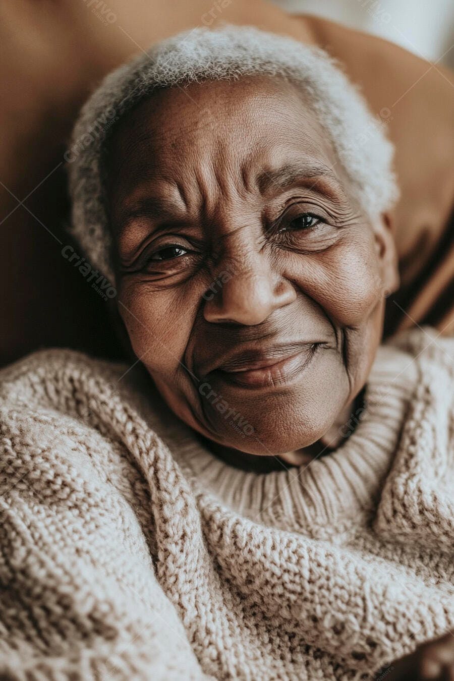 Mulher idosa negra feliz com cabelo branco e suéter bege olhando para a câmera