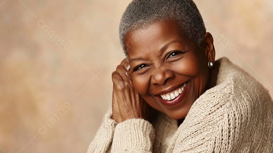 Mulher negra idosa sorrindo feliz com cabelo grisalho e suéter bege