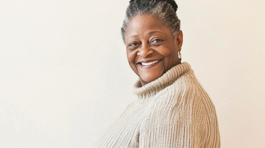 Mulher idosa negra sorrindo com suéter de gola alta bege claro em retrato