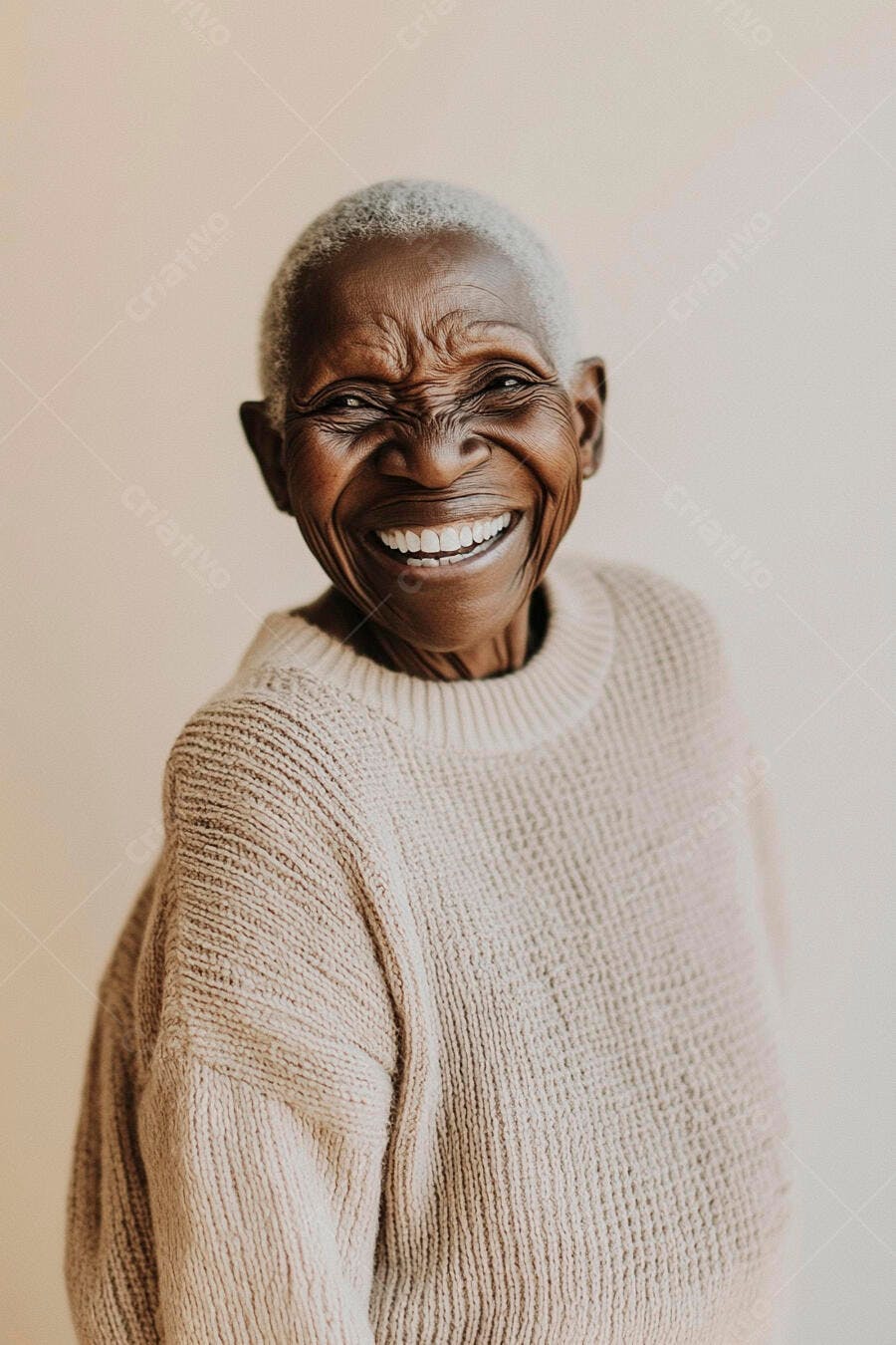 Mulher idosa negra de cabelos grisalhos rindo feliz com suéter bege