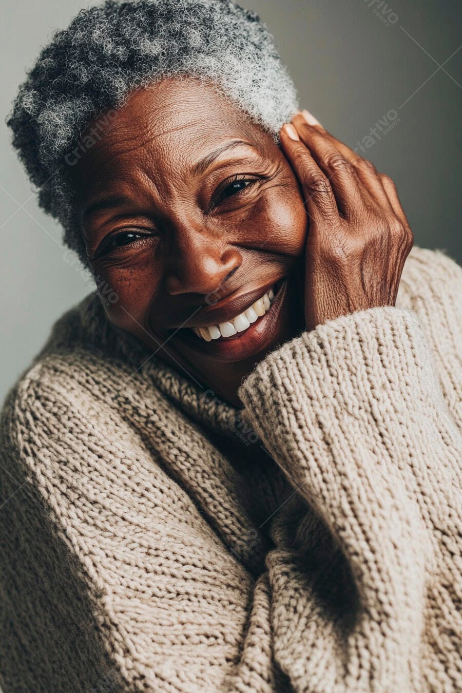 Mulher negra idosa sorrindo com cabelo grisalho e suéter bege