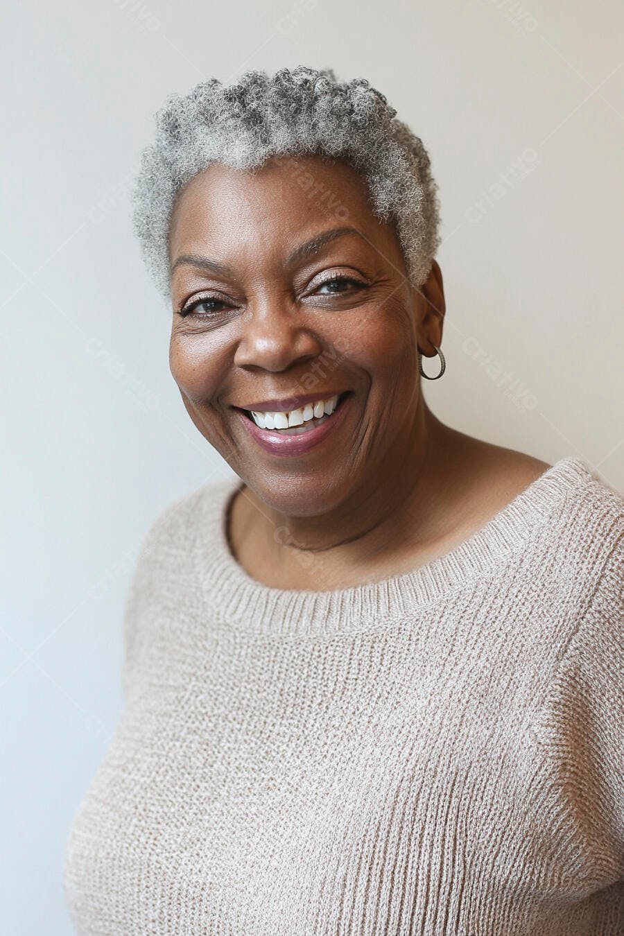 Mulher negra idosa sorrindo com cabelo grisalho e suéter bege claro
