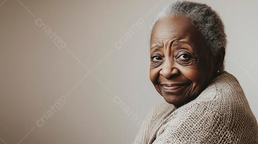 Mulher idosa negra sorrindo com suéter bege em fundo claro