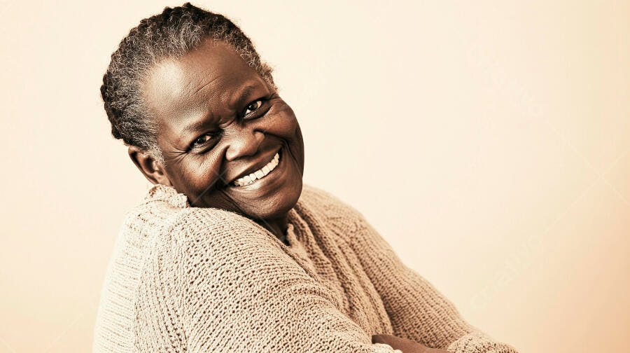 Mulher idosa negra sorrindo feliz em suéter bege claro fundo creme
