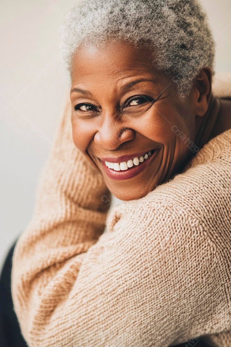 Mulher idosa negra sorrindo feliz com cabelo grisalho e suéter bege