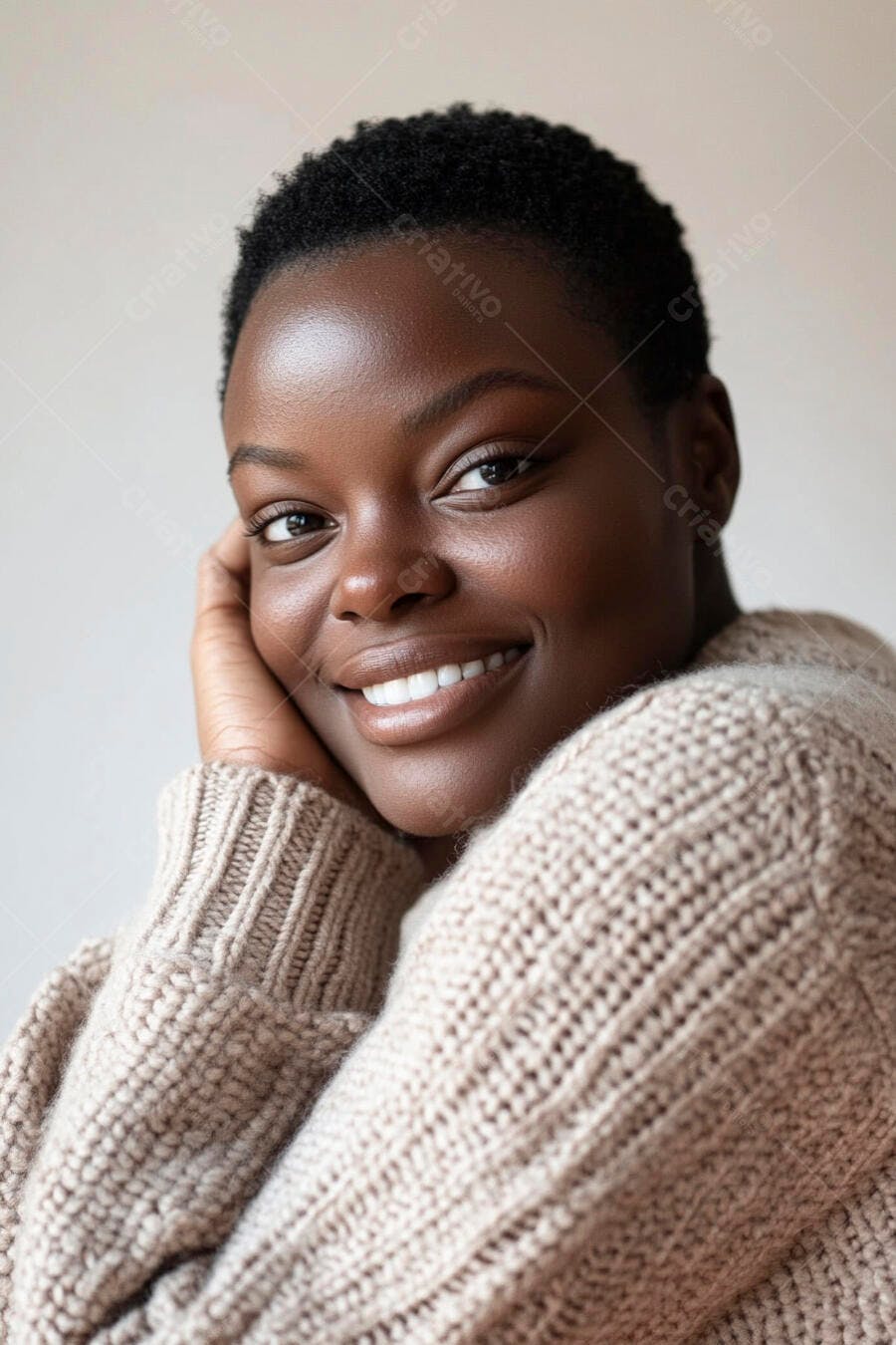Mulher negra sorrindo vestindo suéter bege com fundo claro