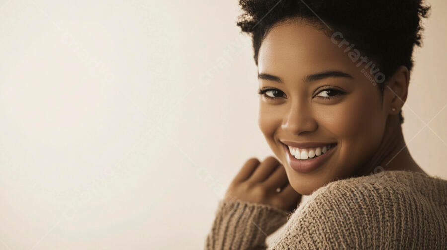 Mulher negra jovem sorrindo feliz usando suéter marrom claro em estúdio