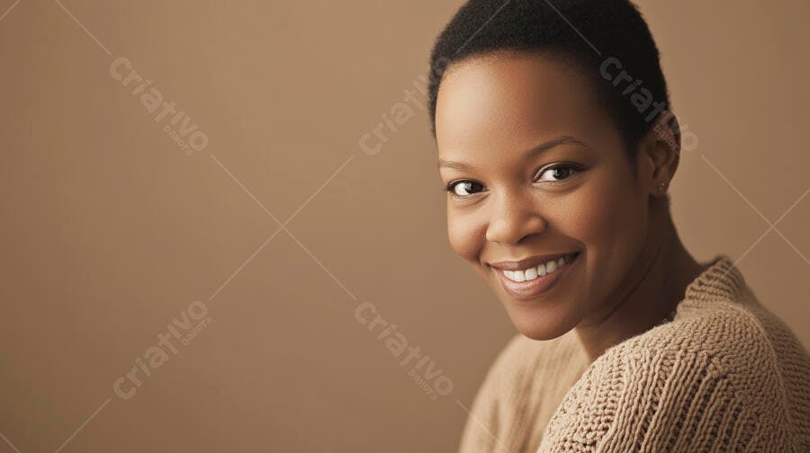 Mulher negra jovem sorrindo com suéter bege em fundo neutro marrom