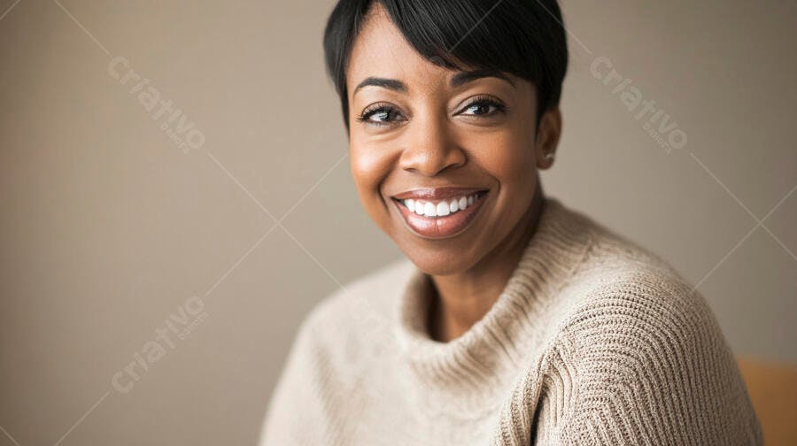 Mulher negra sorrindo com suéter bege em retrato de close-up