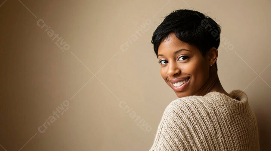 Mulher negra jovem sorrindo com suéter bege olhando para trás