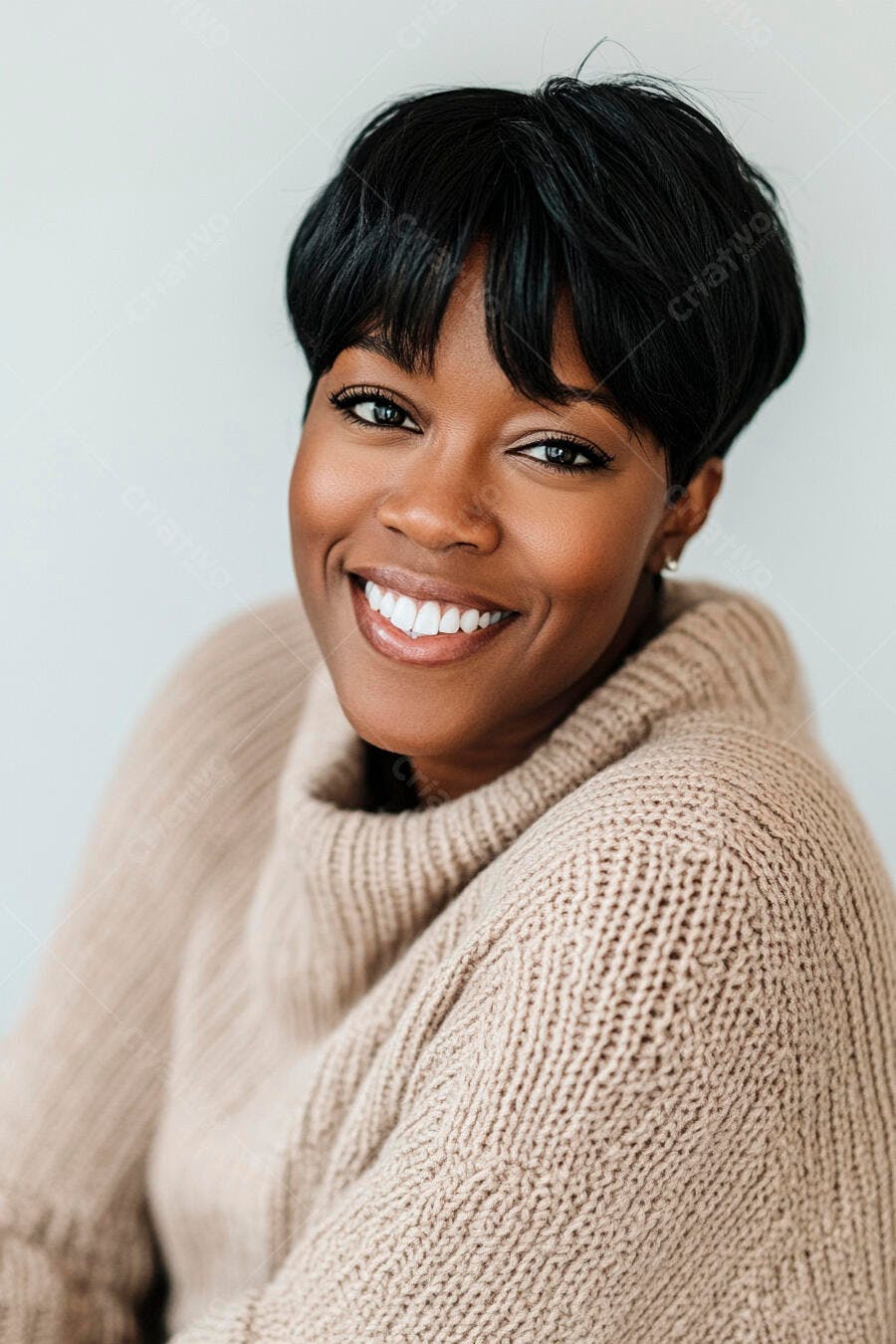 Mulher negra sorrindo suéter bege cabelo curto em estúdio