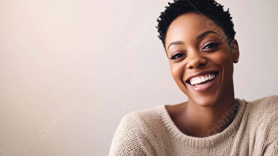 Mulher negra sorrindo radiantemente com cabelo curto e suéter bege em fundo claro