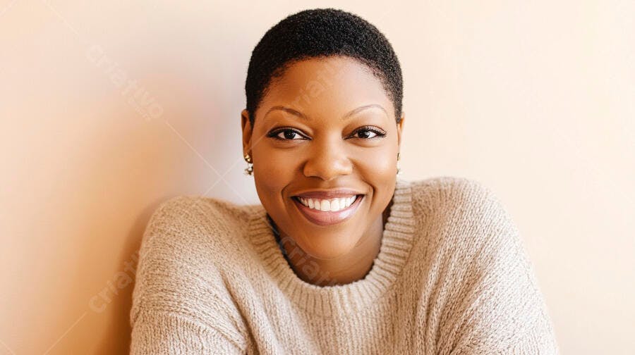 Mulher negra sorridente em suéter bege em fundo pêssego claro