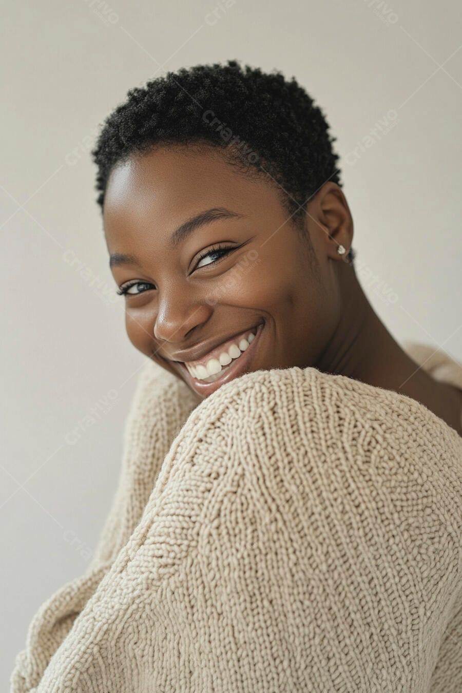 Mulher negra feliz de cabelo curto sorrindo em estúdio com suéter creme