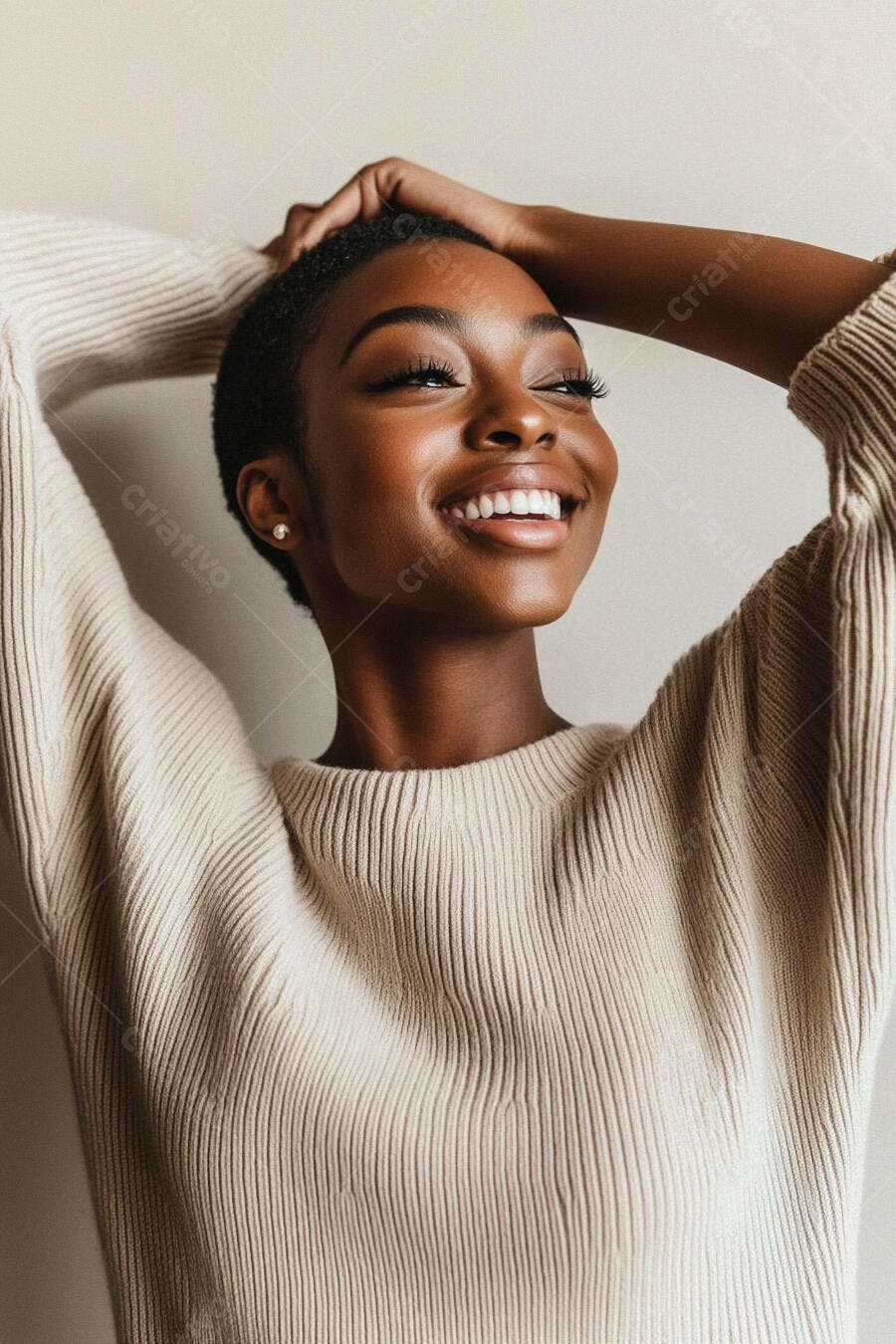 Mulher negra sorrindo feliz de suéter bege com as mãos na cabeça