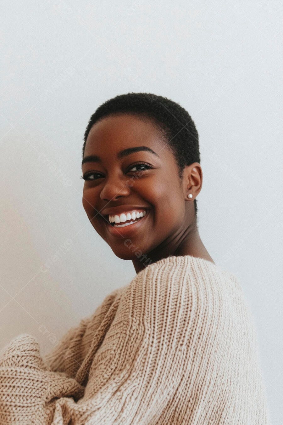 Mulher negra jovem sorrindo feliz com suéter de tricô bege