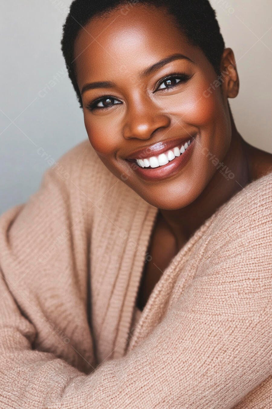 Mulher negra sorrindo com cabelo curto e suéter bege em fundo claro