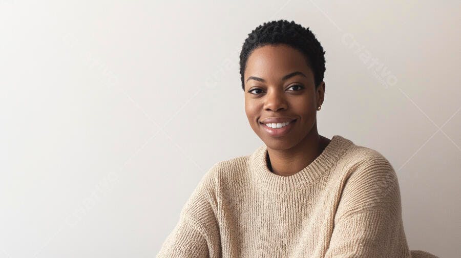 Mulher negra sorridente com suéter bege em fundo neutro
