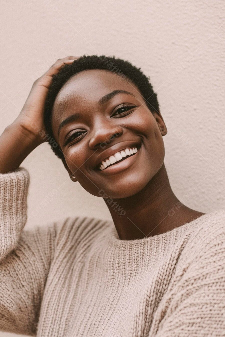 Mulher negra sorrindo com a mão na cabeça usando suéter bege casual