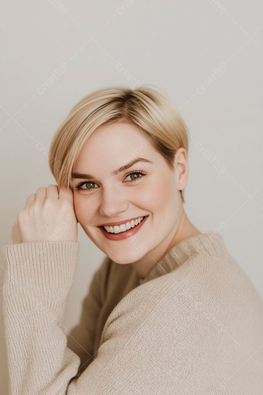 Mulher caucasiana loira de cabelo curto e olhos verdes sorrindo feliz com suéter bege