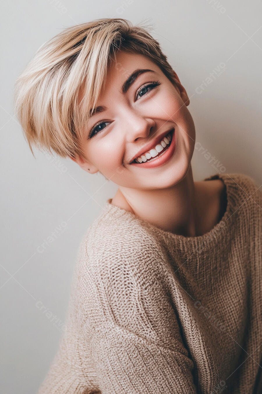 Mulher jovem sorrindo com cabelo loiro curto e suéter bege claro