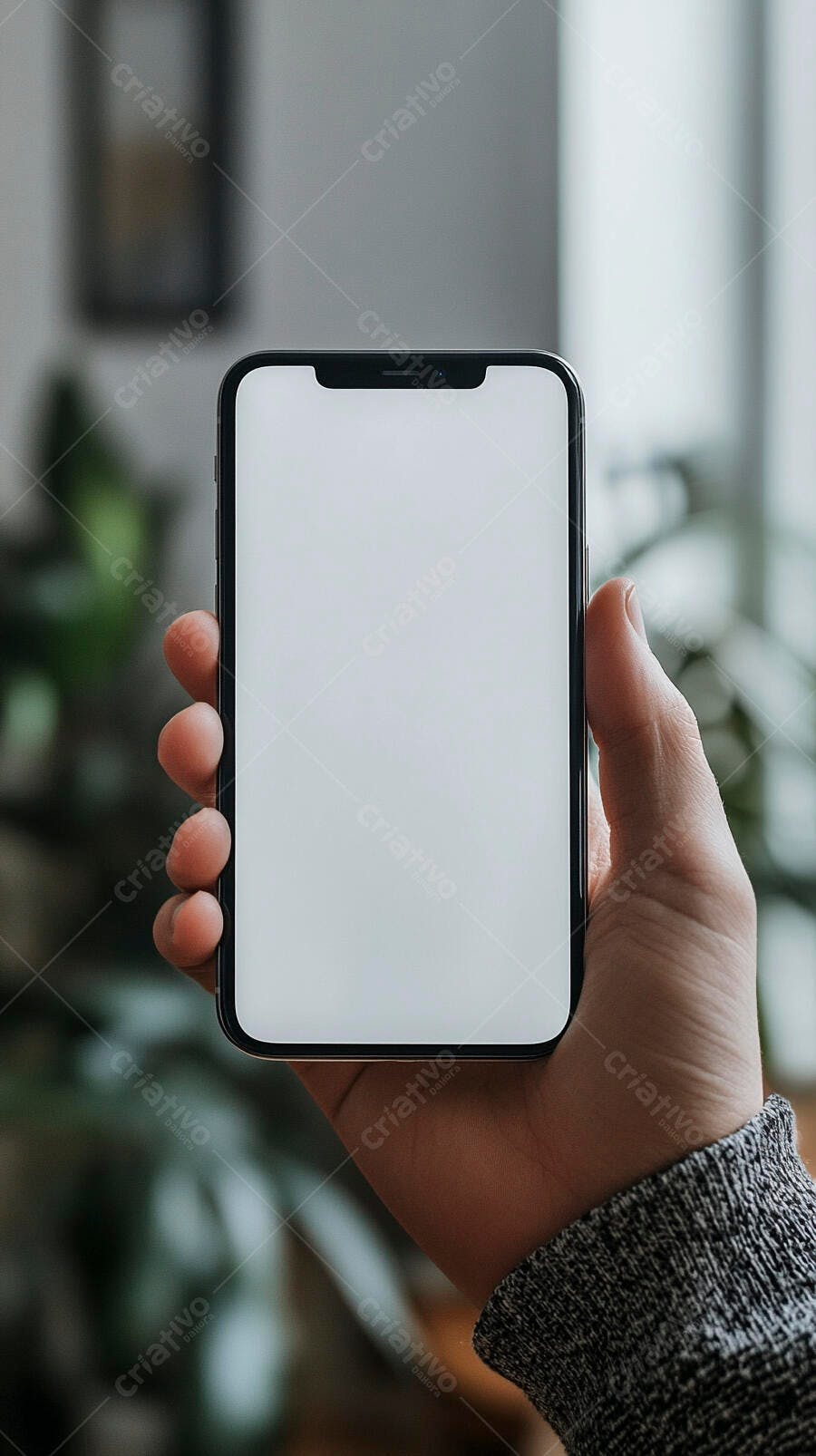 Mão segurando smartphone com tela branca limpa e fundo desfocado