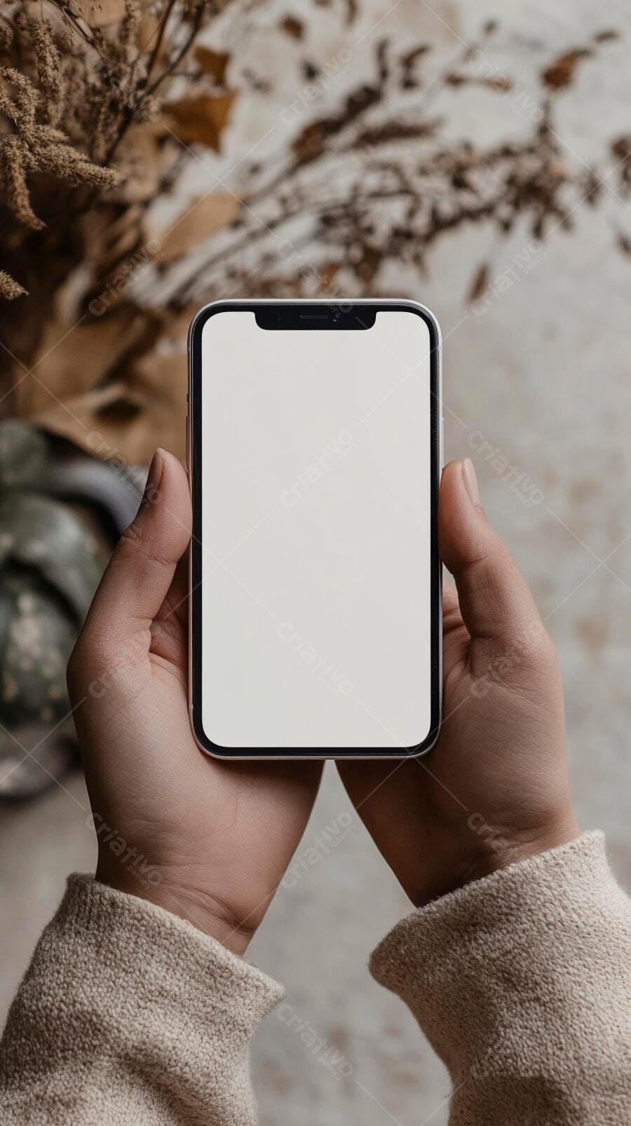 Pessoa segurando smartphone tela em branco mockup com suéter bege fundo outonal