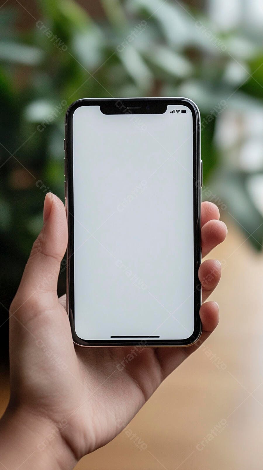 Mão segurando smartphone com tela em branco mockup fundo verde e madeira