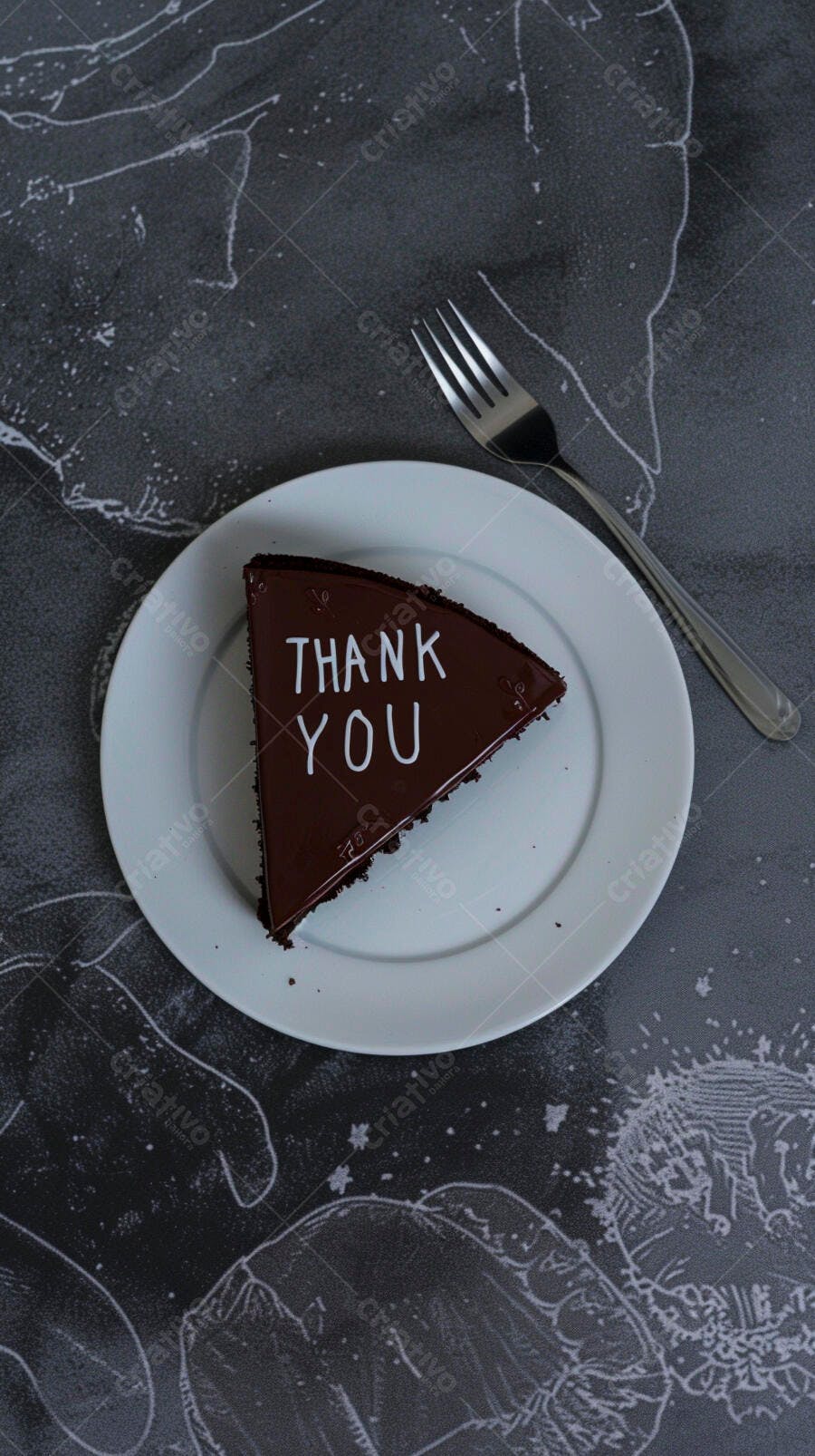 Fatia de bolo de chocolate com "Thank You" em prato branco e garfo