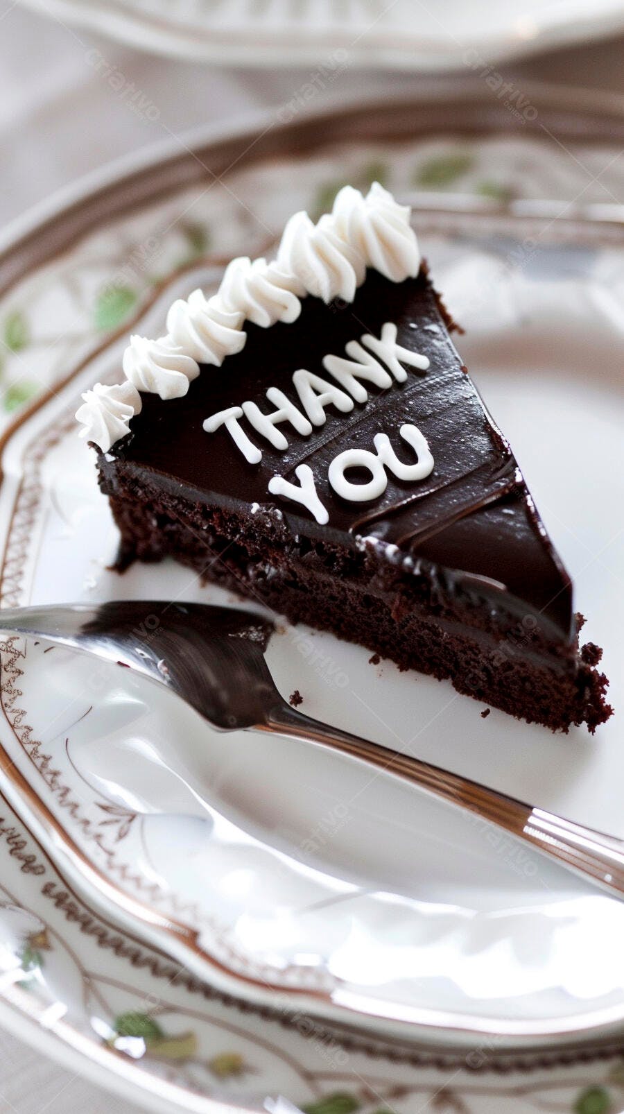 Fatia de bolo de chocolate com "Thank You" e chantilly em prato decorado