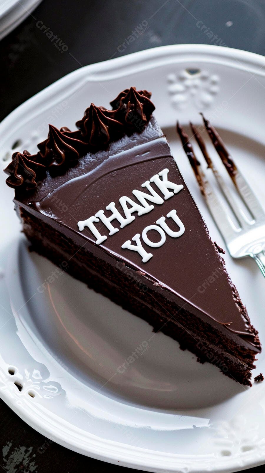 Fatia de bolo de chocolate escuro com a mensagem THANK YOU e garfo sujo