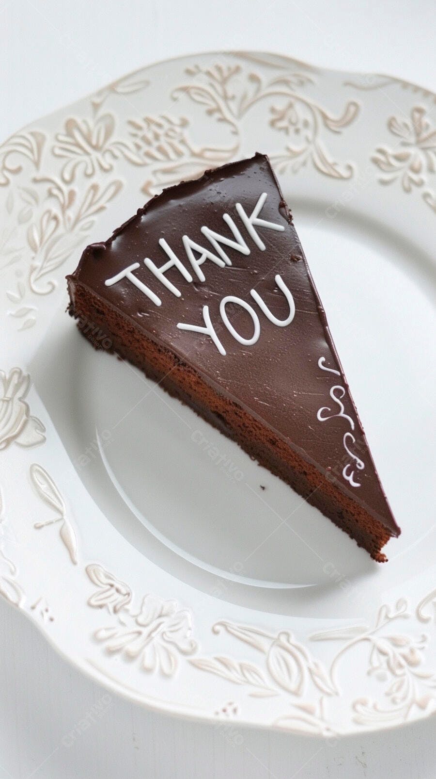 Fatia de bolo de chocolate com 'Thank You' e glacê branco em prato decorado
